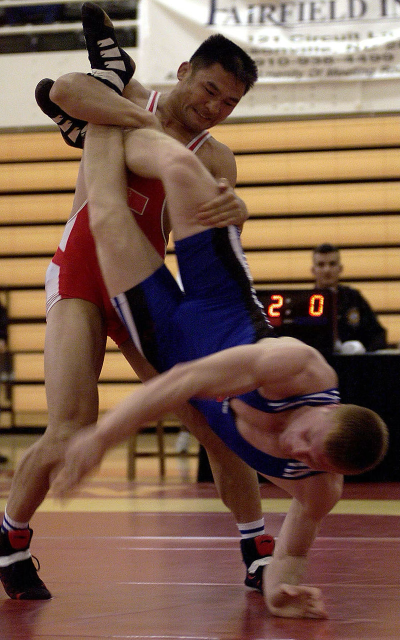 figure shows two wrestlers, one wearing red and the other wearing blue